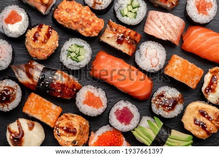 Assorted sushi nigiri and maki big set on slate. A variety of Japanese sushi with tuna, crab, salmon, eel and rolls. Top view