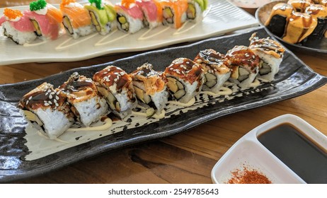 Assorted sushi rolls beautifully arranged, featuring vibrant toppings like fresh salmon, tuna, and avocado, drizzled with soy glaze and garnished with sesame seeds. A delightful Japanese dining meals. - Powered by Shutterstock