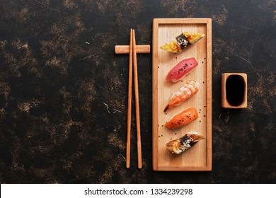 Assorted sushi set on a dark rustic background. Japanese food sushi on a wooden plate, soy sauce, chopsticks. Top view,copy space. - Powered by Shutterstock