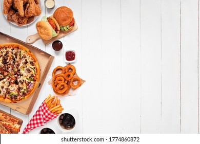 Assorted take out or delivery foods. Side border. Pizza, hamburgers, fried chicken and sides. Above view on a white wood background with copy space.