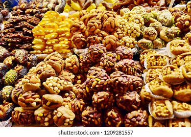 Assorted traditional Turkish delight mixed ingredients with palm date fruit and various nut design in dessert for sale at Spices bazaar in Istanbul Turkey, sweet for business concept