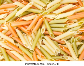 Assorted uncooked penne pasta close up background