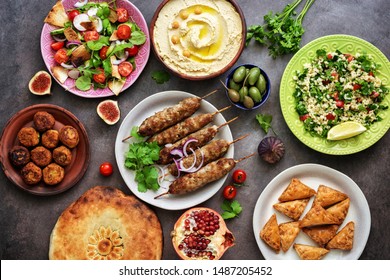 Assorted Variety Of Arabic And Middle Eastern Food On A Dark Rustic Background. Hummus,tabbouleh Salad, Salad Fattoush,pita,meat Kebab,falafel,baklava. Set Of Arabian Dishes.Top View