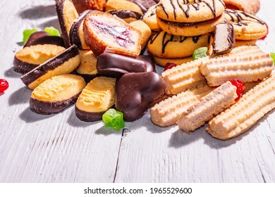 Assorted various cookies and cupcakes. Trendy hard light, dark shadow. White wooden boards background, copy space