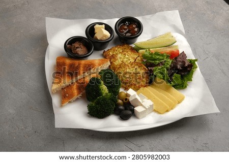Assorted vegetarian appetizer plate with toasted bread, vegetables, cheeses and