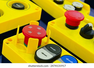 Assorted yellow plastic industrial remotes with buttons and switches, close up shot, selective focus - Powered by Shutterstock