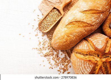 Assortment Of Baked Bread On White Wooden Table Background