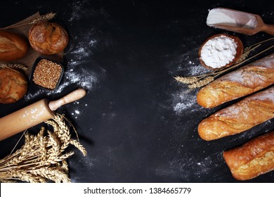 Assortment of baked bread and bread rolls on rustic table background.