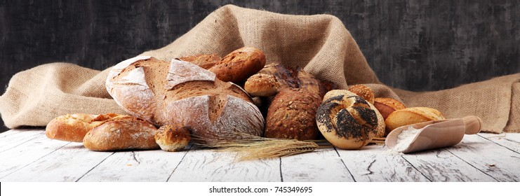 Ensemble de pain et de petits pains cuits sur fond table en bois.