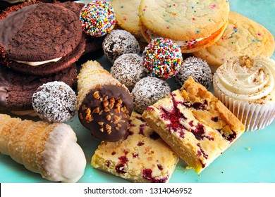 Das Sortiment umfasst gebackene Süßigkeiten, darunter Schokoladenbälle, Vanillekochen, Himbeerquadrate und einen Kuchen mit Ahornverzierungen. 