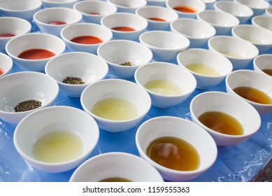 Assortment of basic food flavoring and seasoning ingredients ready for cooking. Ketchup, Red Chili Sauce, Ground Black Pepper, Lime Juice, Fish Sauce in separate bowls on blue table. Natural light.