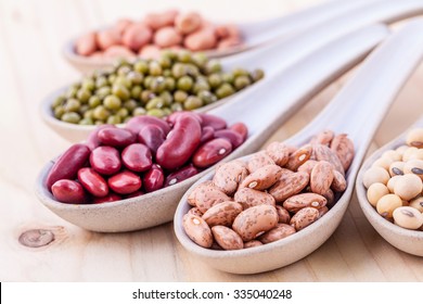 Assortment of beans and lentils in wooden spoon on wooden background. mung bean, groundnut, soybean, red kidney bean , black bean ,red bean and brown pinto beans . - Shutterstock ID 335040248