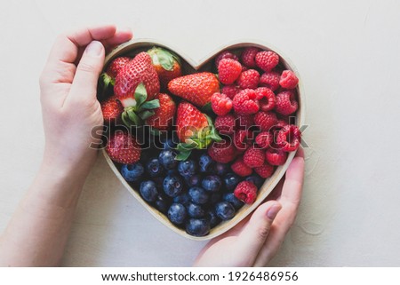 Assortment berries blueberries, strawberries and raspberries in heart woden box. Keto diet, healthy food.