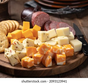 Assortment Of Cheese Cubes With Crackers And Sausage On A Wooden Platter