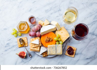 Assortment of cheese, grapes with red and white wine in glasses. Marble background. Top view.
 - Powered by Shutterstock