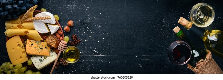 Assortment of cheeses, a bottle of wine, honey, nuts and spices, on a wooden table. Top view. Free space for text. - Shutterstock ID 760605829