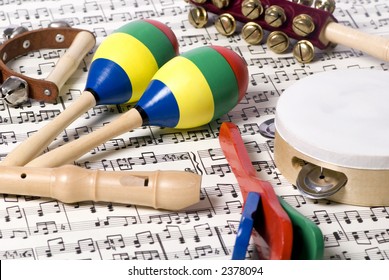 An Assortment Of Childrens Instruments On Top Of A Complicated Score Of Music