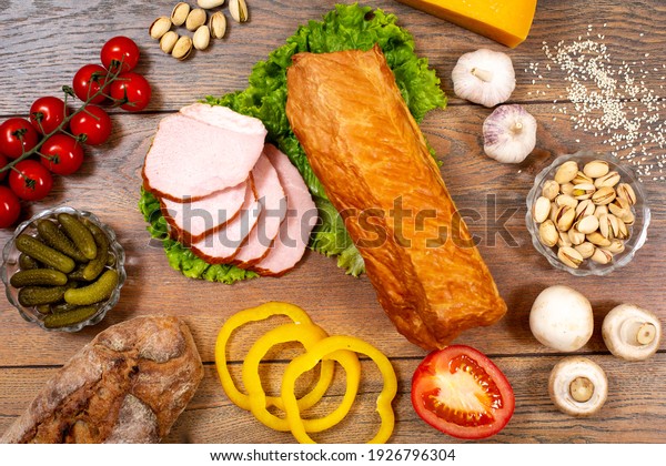 Assortment of cold cuts, a variety of\
processed cold meat products. On a wooden\
background