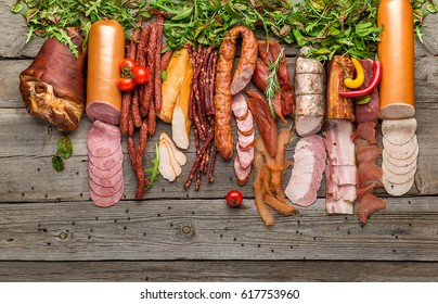 Assortment of cold meats, variety of processed cold meat products. On a wooden background