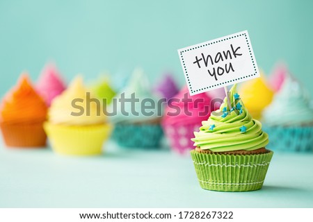 Assortment of colorful cupcakes with thank you sign