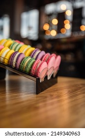 Assortment of colorful french macaroons on a table in cafe. Varieties of macaroni flavors. Cookies in the coffee shop. Close up photo of macaroons