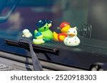 Assortment of colorful rubber duck toys on a car dashboard