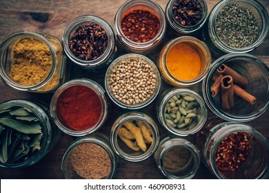 Assortment of colorful spices in glass jars.