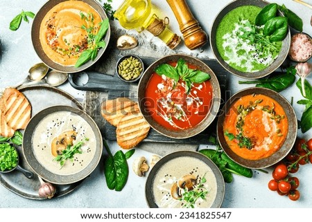 Assortment of colorful vegetable soups: spinach, mushrooms, carrots and pumpkin. In a bowl. The concept of dietary nutrition. Top view.