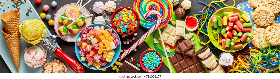 An assortment of colourful, festive sweets, ice-cream and candy in a panoramic orientation.