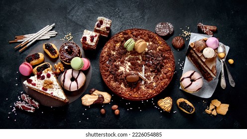 Assortment of confectionery, different types desserts on dark table. Top view - Shutterstock ID 2226054885