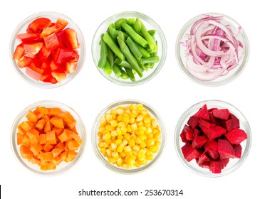 Assortment Of Cut Vegetables In Glass Bowls Isolated On White Background. Top View.