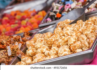An assortment of different candies at a buffet in different serving dishes