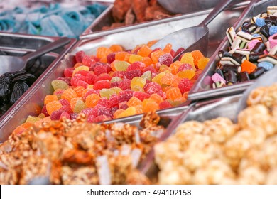 An assortment of different candies at a buffet in different serving dishes