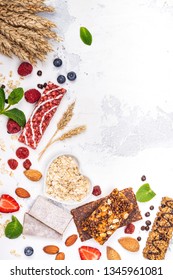 Assortment Of Different Granola Cereal Bars On White Stone Background. Healthy Pre Or Post Workout Snacks With Fruits, Nuts And Berries. Copy Space. Top View