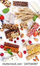 Assortment Of Different Granola Cereal Bars On White Stone Background. Healthy Pre Or Post Workout Snacks With Fruits, Nuts And Berries. Copy Space. Top View