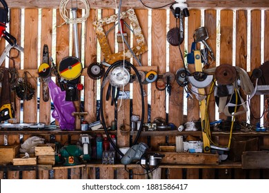 assortment of do it yourself tools hanging in a wooden cupboard against a wall