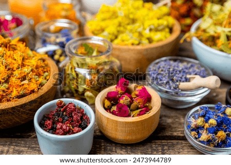 Assortment of dry herbal and berry tea on a wooden background. Tea party concept. medicinal herbs. Healing herbs.Alternative medicine.Linden, calendula, cornflowers, marigold, tansy, tea rose.
