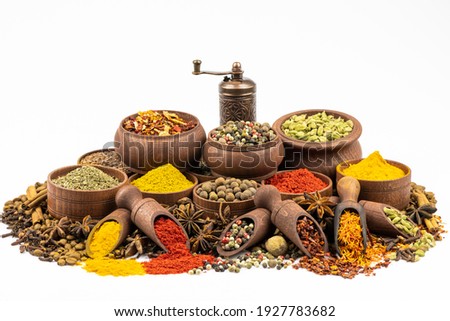 Assortment of east spices and seasonings in wooden tableware by close up isolated on a white background.