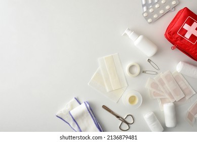 Assortment Of Emergency First Aid Kit Objects On The Corner Of A White Table. Horizontal Composition. Top View. 