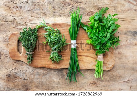 Assortment of fresh aromatic herbs from above on old wood background. Parsley, Mint, Thyme, Basil, Oregano, Rosemary, Chives and estragon.Flat lay.Top view