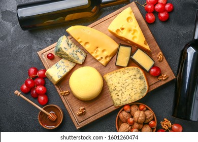 Assortment fresh cheeses and wine dark background