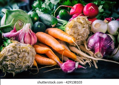 Assortment of fresh vegetables. Carrot garlic kohlrabi onion celery cucumber parsnip and radish on table.