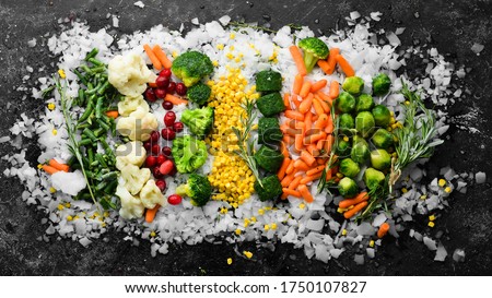 Assortment of frozen vegetables on ice. Stocks of food. Top view. Free space for your text.