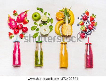 Assortment of fruit  and vegetables smoothies in glass bottles with straws on white wooden background. Fresh organic Smoothie ingredients. Superfoods and health or detox  diet food concept.