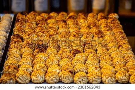 Assortment of golden pine nut panellets on a tray fresh from the oven for Chestnut Day in Catalonia celebrated along with Halloween and All Saints.