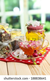 Assortment of herbs, honey and tea in glass jars on wooden table, on bright background  - Shutterstock ID 188838641
