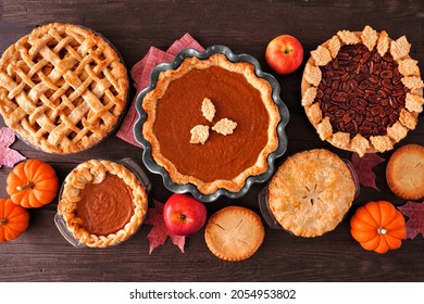 Assortment Of Homemade Fall Pies. Apple, Pumpkin And Pecan. Top Down View Table Scene On A Dark Wood Background.