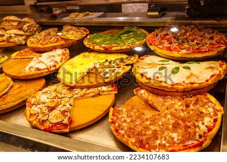 Assortment of italian pizza in the showcase of pizzeria
