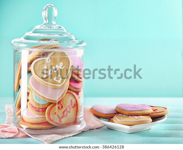 Assortment of\
love cookies in jar on blue\
background
