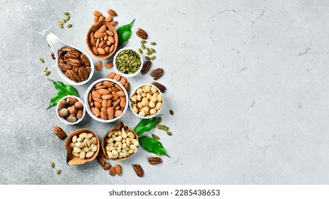 Variedad de nueces en tazones. Cashew, avellanas, nueces, pistachos, pecans, nueces de pino, maní. Fondo de la mezcla de alimentos, vista superior, espacio de copia.